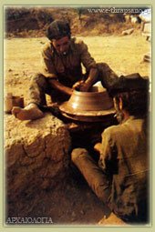 Ο Τροχάρης γυρίζει το τροχί και ο μάστορας διαμορφώνει τον πηλό δημιουργώντας το αγγείο. (Φωτ. Αννα Guest Παπαμανώλη -αγγειοπλάστες: Κων/νος & Εμμ. Κελαράκης) 